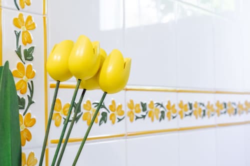 Tulipanes amarillo brillante con decorativo azulejo floral de fondo en el hotel Guest Homes Malaga