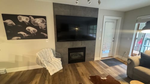 Modern living room with fireplace, flat-screen TV, and comfortable seating in Whistler apartment rental