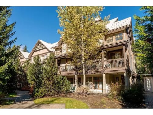 Luxury garden-view apartment at Northstar 37 in Whistler with multi-level deck, mature trees, and modern architecture