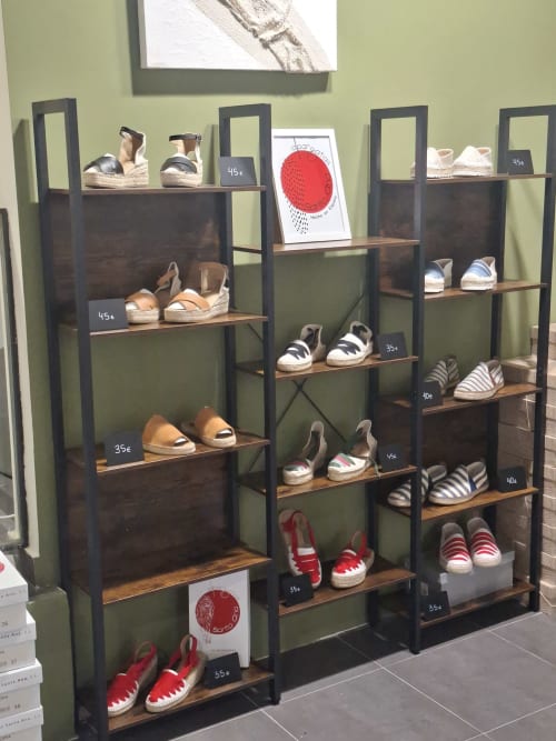 Display shelving with colorful shoes and sneakers at Hotel-Boutique by Gonzalo Sesma in Cervera del Río Alhama