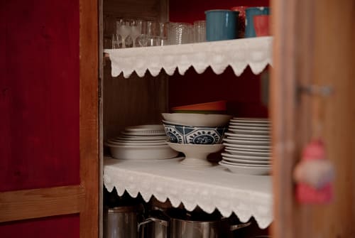 Wooden cabinet with decorative dishware and glasses at Cristallo Apartment in Ravenna