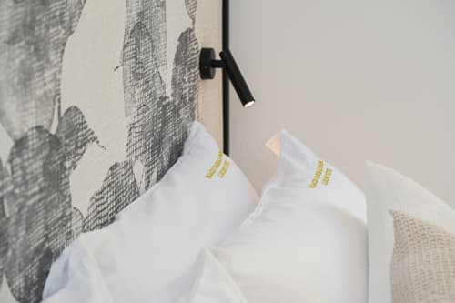 Asciugamani bianchi con branding dorato esposti su portasciugamani all'hotel Palazzo Garibaldi Parma