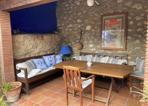 Rustic patio lounge at Casa Gallinera, Benissivà with wooden furniture, stone walls, and blue accents