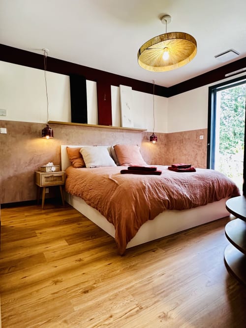 Chambre moderne à  l'Instant Cottage à Amboise avec murs en terre cuite, parquet et luminaires suspendus