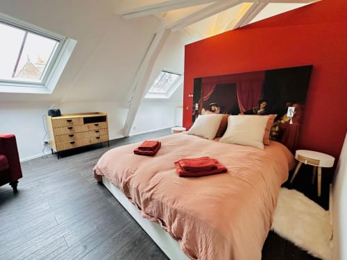 Chambre mansardée contemporaine à l'Instant Clos Lucé, Amboise avec mur d'accent rouge, puits de lumière et mobilier actuel