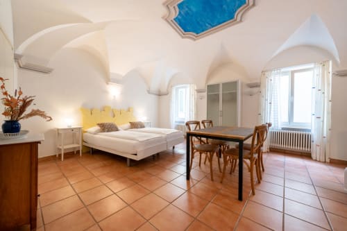 Appartement supérieur à la Résidenza Motta à Locarno avec chambre, salle à manger, plafond voûté et vue sur le jardin