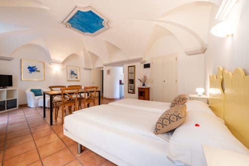 Appartamento superior alla Residenza Motta Locarno con letto, zona pranzo, soffitto a volta e vista sul giardino