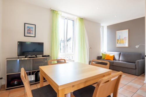 Séjour moderne avec salle à manger, télévision, canapé et vue sur le jardin à la Residenza Motta de Locarno
