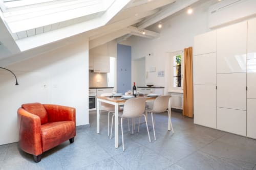 Penthouse moderne à la Residenza Motta Locarno avec chaise rouge, table à manger et cuisine ouverte