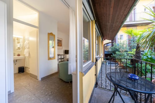 Studio à la Résidenza Motta à Locarno avec séjour ouvert, cuisine moderne, salle de bain et vue sur le jardin