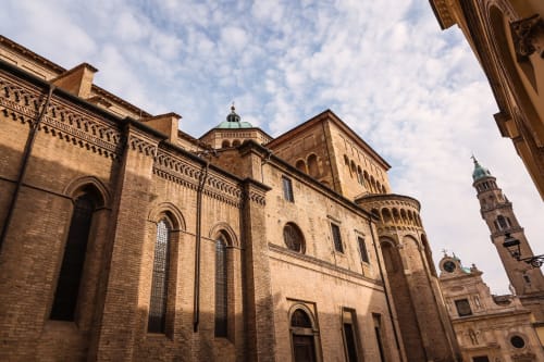 Historic brick cathedral with green dome in Parma, Italy near Palazzo Garibaldi Parma hotel