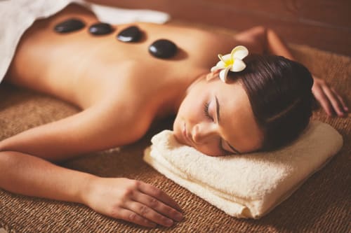Femme se détendant lors d'un soin spa aux pierres chaudes à l'hôtel Anne Duval à Saint-Florent, Corse