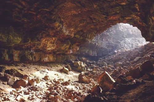 Cave interior with rocky floor and natural light opening at Posada La Colodra, Spain