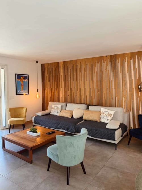 Salon moderne de la villa Casa Incantu aux Villas d'A Storia, Porto-Vecchio, avec canapé, fauteuils et mur en bois