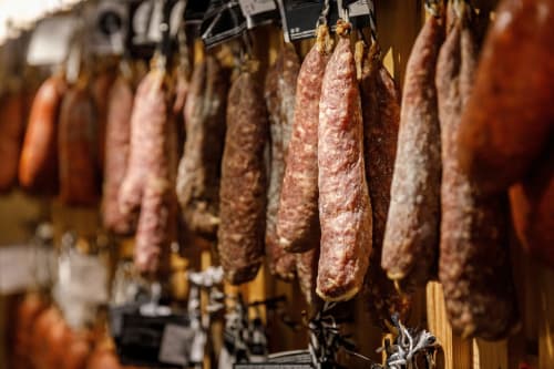 Cured meats hanging in traditional Spanish deli display at Posada La Colodra