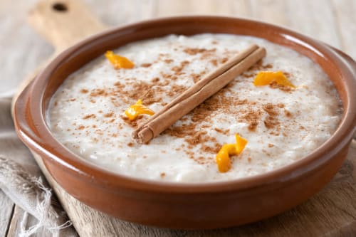 Creamy soup with cinnamon stick and orange zest in terracotta bowl at Posada La Colodra