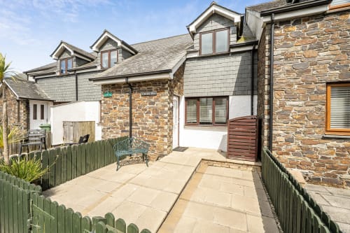 Archies Place cottage in Padstow features stone and slate exterior with patio garden access and green fencing