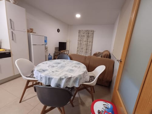 Open-plan apartment living area in Algemesí with dining table, modern kitchen, refrigerator, sofa, and TV entertainment setup
