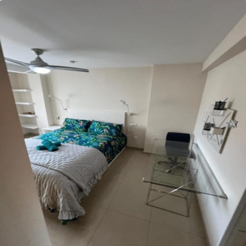 Modern bedroom at Algemesi Home with queen bed, turquoise bedding, desk area, and ceiling fan in Algemesí apartment