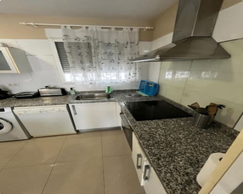 Modern kitchen in Algemesí Home apartment with white cabinets, granite countertops, stainless steel hood, and equipped