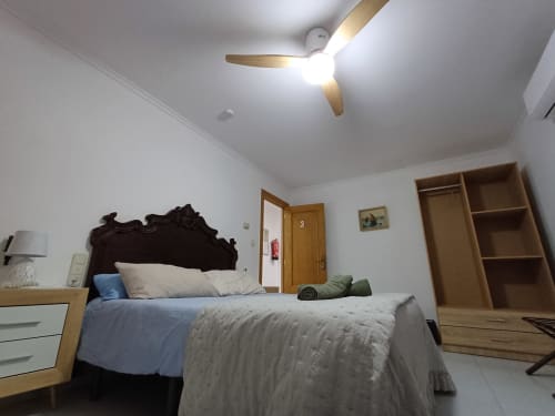 Spacious bedroom in San Jose Luminoso apartment, Algemesi with modern ceiling fan, wooden wardrobe, and ornate dark headboard