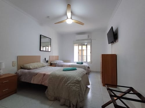 Bright bedroom at Algemesi Home with two beds, ceiling fan, TV, and balcony views in Algemesi, Spain
