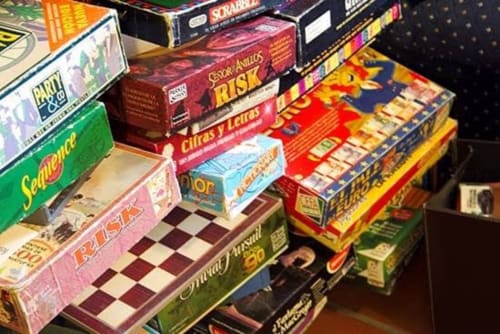 Stacked classic board games including Risk and Scrabble at Posada La Colodra hotel in Los Tojos