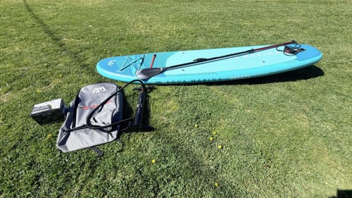 Planche de paddle gonflable bleue avec pagaie sur l'herbe aux Villas Vallée d'Asco, Moltifao