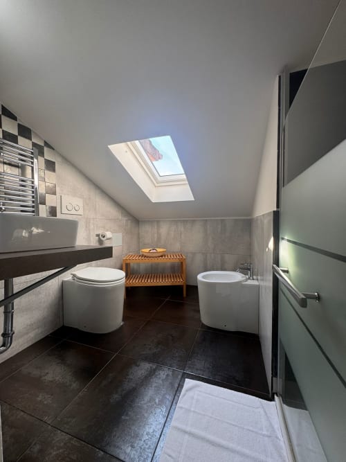 Baño moderno con tragaluz, bañera de inmersión, inodoro y banco de madera en B&B Residenza Leonardo, Falconara Marittima