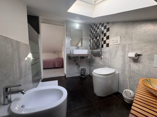 Baño moderno en B&B Residenza Leonardo, Falconara Marittima, con dobles lavamanos, azulejos blanco y negro, claraboya y
