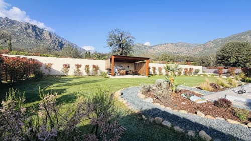 Luxury villa garden in Corsica with mountain views, spacious lawn, modern pavilion, and landscaped terraces at Villas Vallée