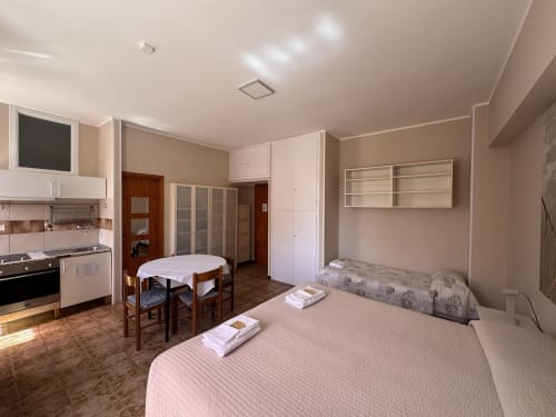 Habitación triple en B&B Residenza Leonardo, Falconara Marittima con camas, cocineta y vistas al jardín