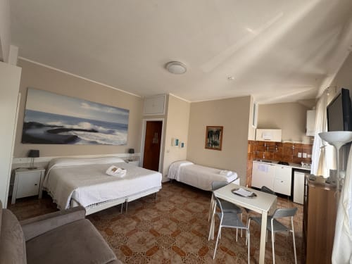 Habitación familiar B&B Residenza Leonardo en Falconara Marittima con dos camas, cocina americana y cuadros con vistas a la montaña