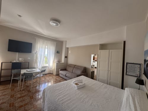 Habitación espaciosa en B&B con cama queen, sofá, escritorio, TV y kitchenette en Residenza Leonardo, Falconara Marittima