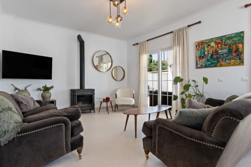Elegante sala de estar de Ayma Villa Olsson en Alhaurín de la Torre con mobiliario moderno, chimenea y vistas a la terraza