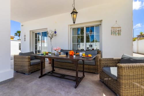 Soleada terraza de Ayma Villa Olsson en Alhaurín de la Torre con asientos de mimbre, mesa de comedor y vistas al jardín