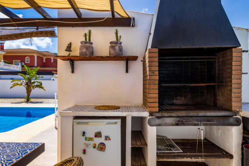 Cocina exterior con parrilla y refrigerador con vistas a la piscina en Villa Olsson en Alhaurín de la Torre