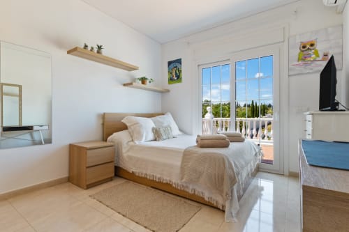 Habitación luminosa en Ayma Villa Olsson, Alhaurín de la Torre, con cama de madera, acceso a terraza y vistas a la piscina