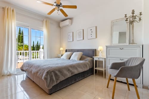 Amplio dormitorio en Ayma Villa Olsson con vista a la piscina, mobiliario moderno, ventilador de techo, aire acondicionado y acceso a terraza en Alhaurín de