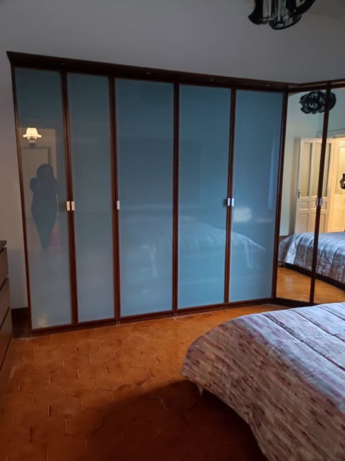 Camera moderna con armadi sfumature blu, pavimento in spina di pesce in legno, e letto a Maison Platone Jolie ad Alessandria