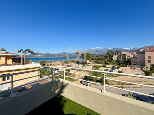 Vue mer depuis la terrasse de la Résidence Saint Philippe à L'Île-Rousse, Corse, surplombant la baie avec montagnes et accès à la plage