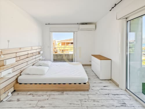 Chambre moderne et lumineuse à L'Île-Rousse avec vue mer, lit en bois, literie blanche et accès terrasse