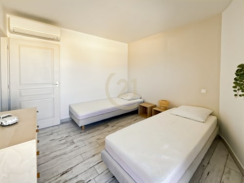 Chambre double lumineuse dans l'appartement de L'Île-Rousse avec deux lits, parquet, climatisation et accès à la vue mer
