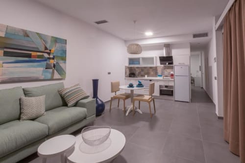 Suite moderne à l'Aevum Resort à Playa del Inglés avec séjour ouvert, cuisine, salle à manger et mobilier contemporain