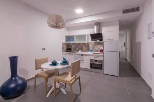 Cuisine moderne et salle à manger de la Suite terrazza à l'Aevum Resort, Playa del Inglés, avec mobilier blanc et design contemporain