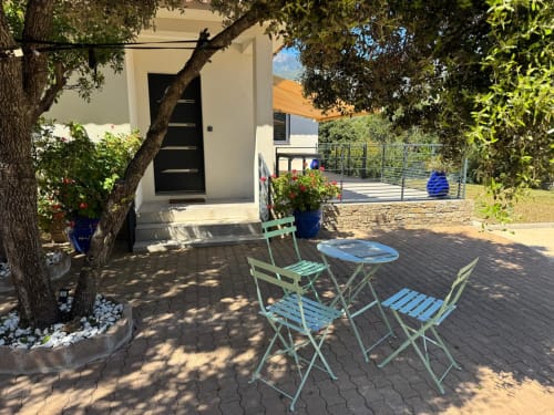 Mint green outdoor dining set under shade tree at Villa A Santa, Figari, with private courtyard and mountain views