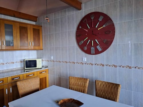 Modern kitchen with wooden cabinets, cream microwave, and dining table with wicker chairs at Inn Nature villa in São Roque do