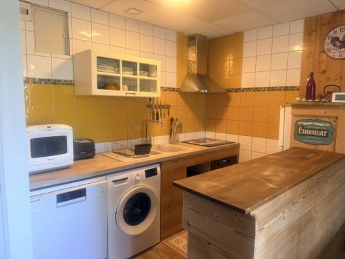 Cuisine rustique avec carrelage jaune, comptoirs en bois et électroménagers modernes aux Gîtes Des Planchettes à Marigny