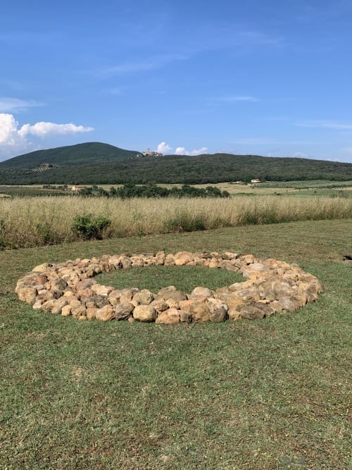 Anillo de fuego de piedra en la campiña toscana de Casale Artemisia, Capalbio, con colinas ondulantes y cielo azul