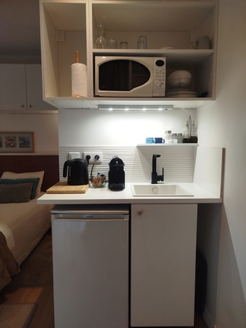 Kitchenette moderne à l'appartement Villa Voltaire avec micro-ondes, évier et placards à Clamart